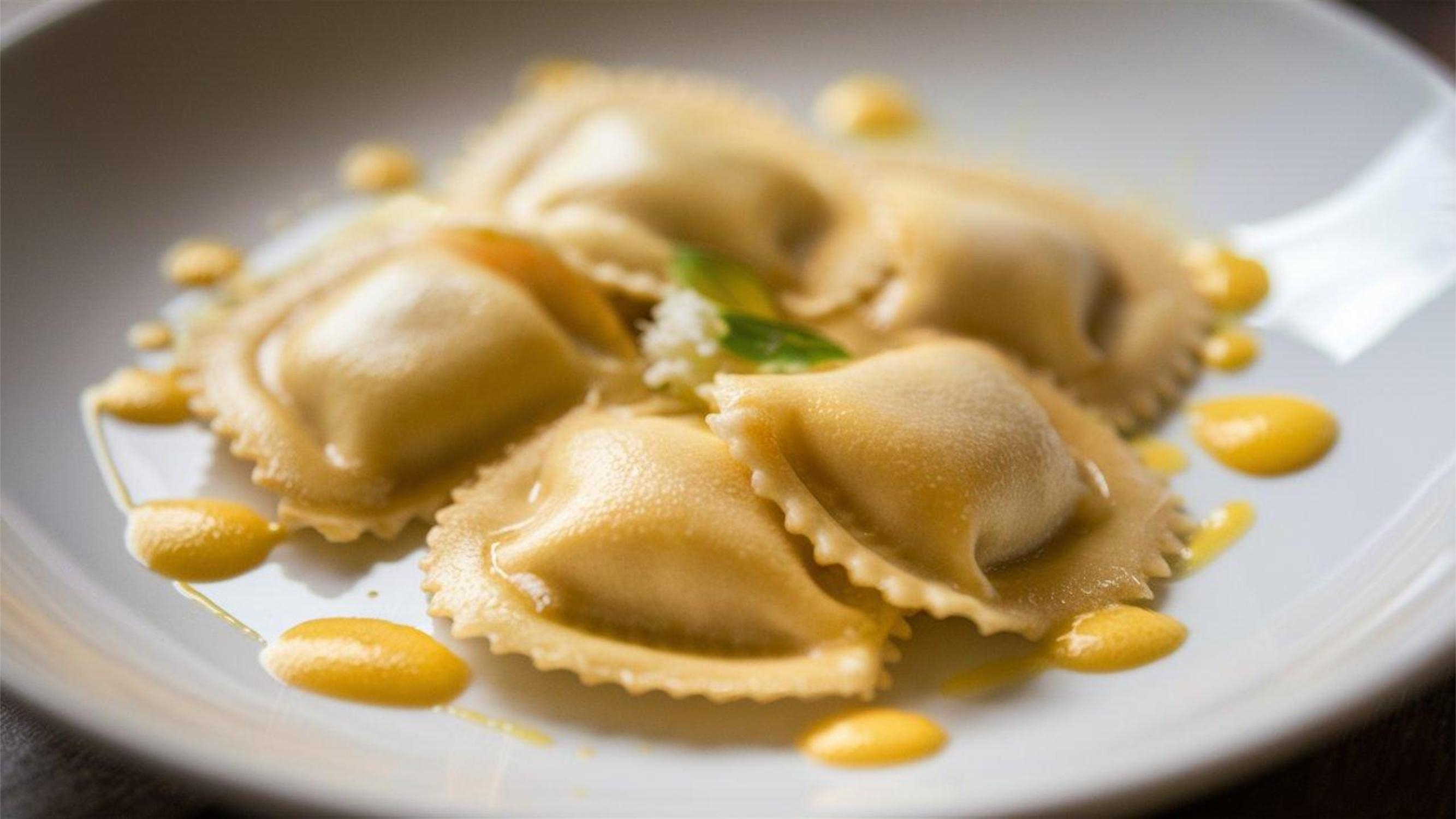 Friske italienske ravioli med citron-ricotta fyld serveret med citrus smørsauce og pinjekerner på hvid tallerken