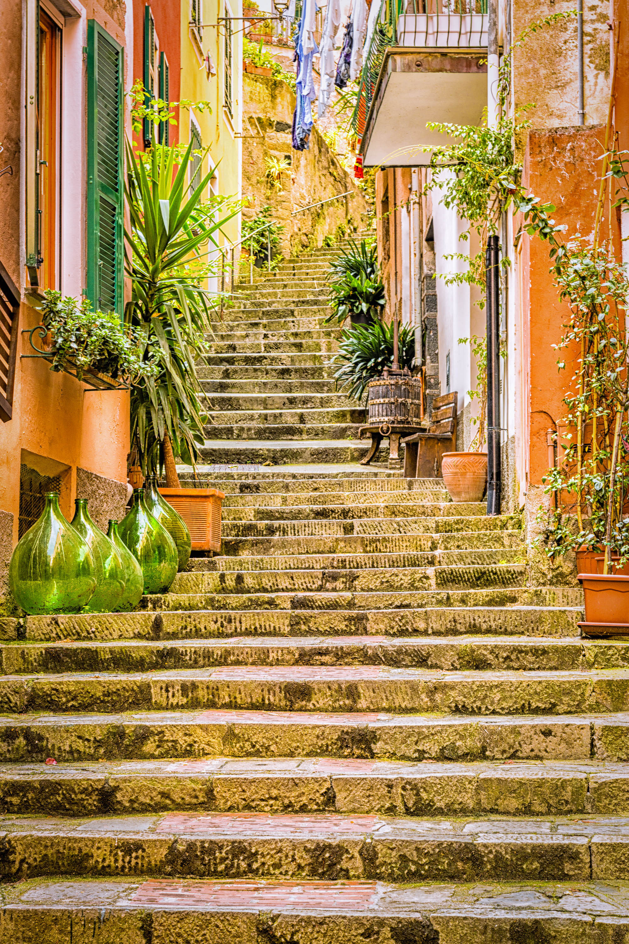 Farverige stentrapper i pittoresk italiensk landsby med traditionelle orange og gule huse