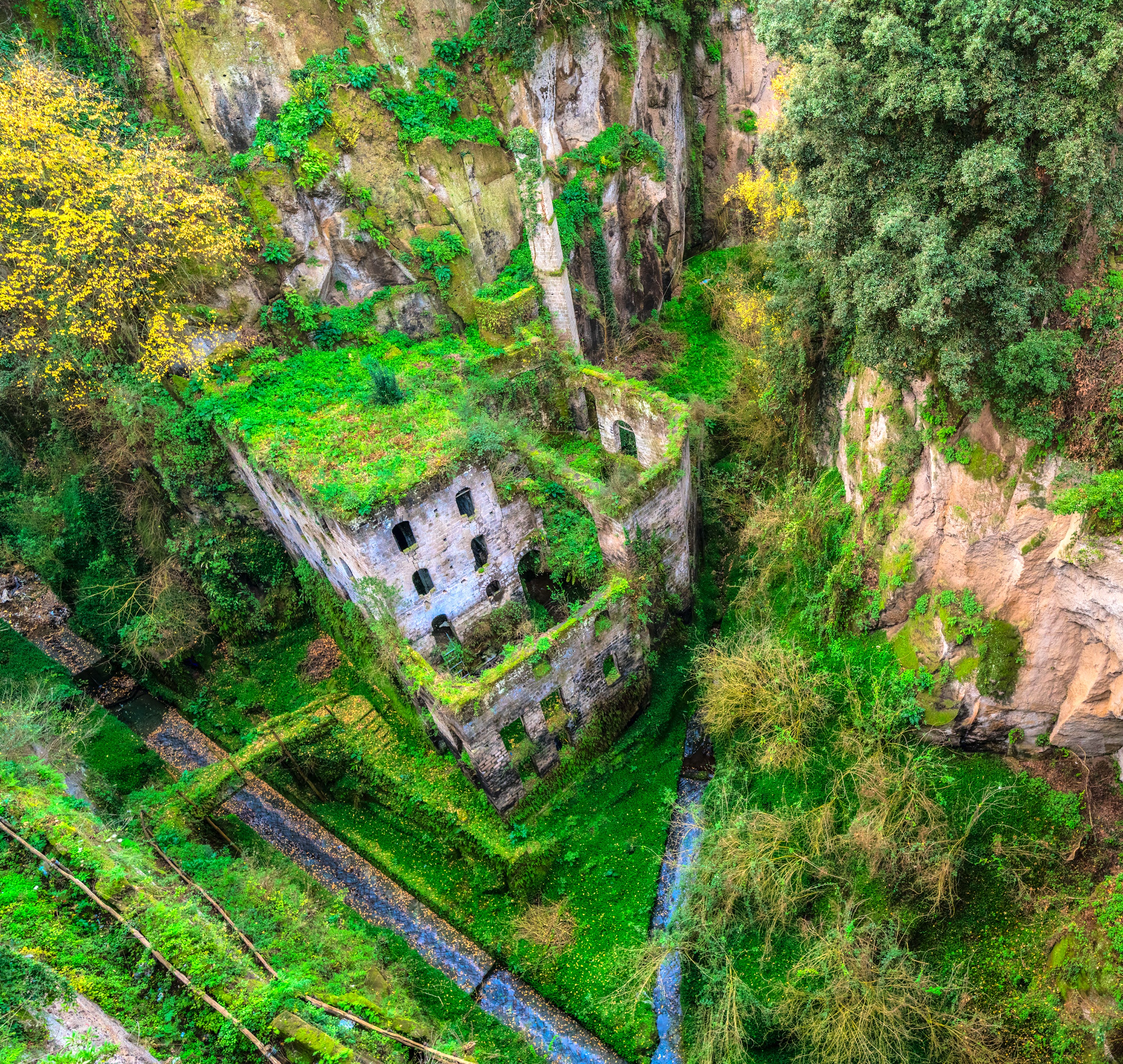Gamle italienske ruiner omgivet af frodig grøn natur i bjerglandskab