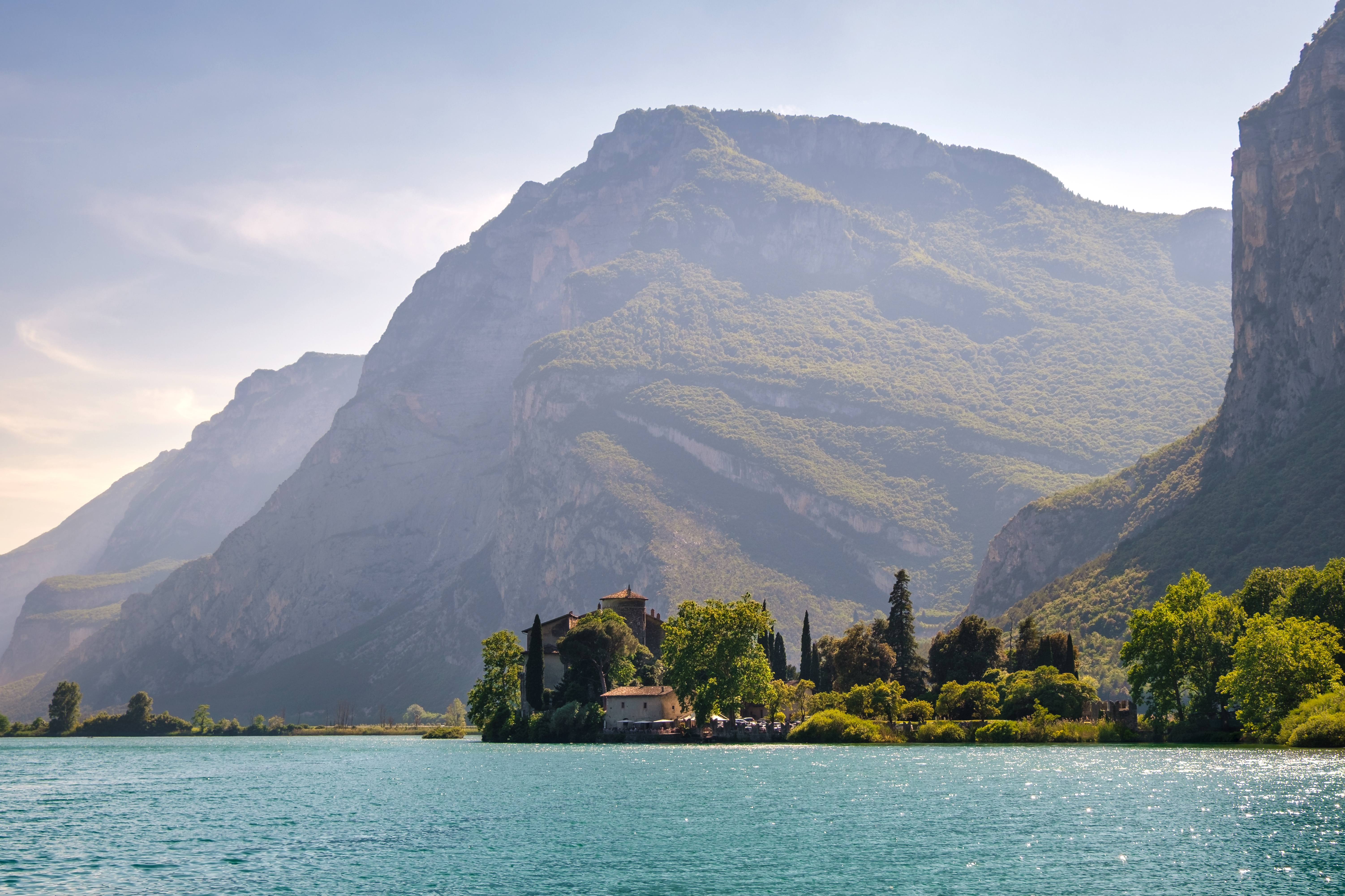 Smuk italiensk sø omgivet af majestætiske bjerge og historisk villa med frodig vegetation
