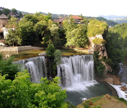 Det historiske Jajce vandfaldet og middelalderborgen i Bosnien Hercegovina omgivet af grøn natur