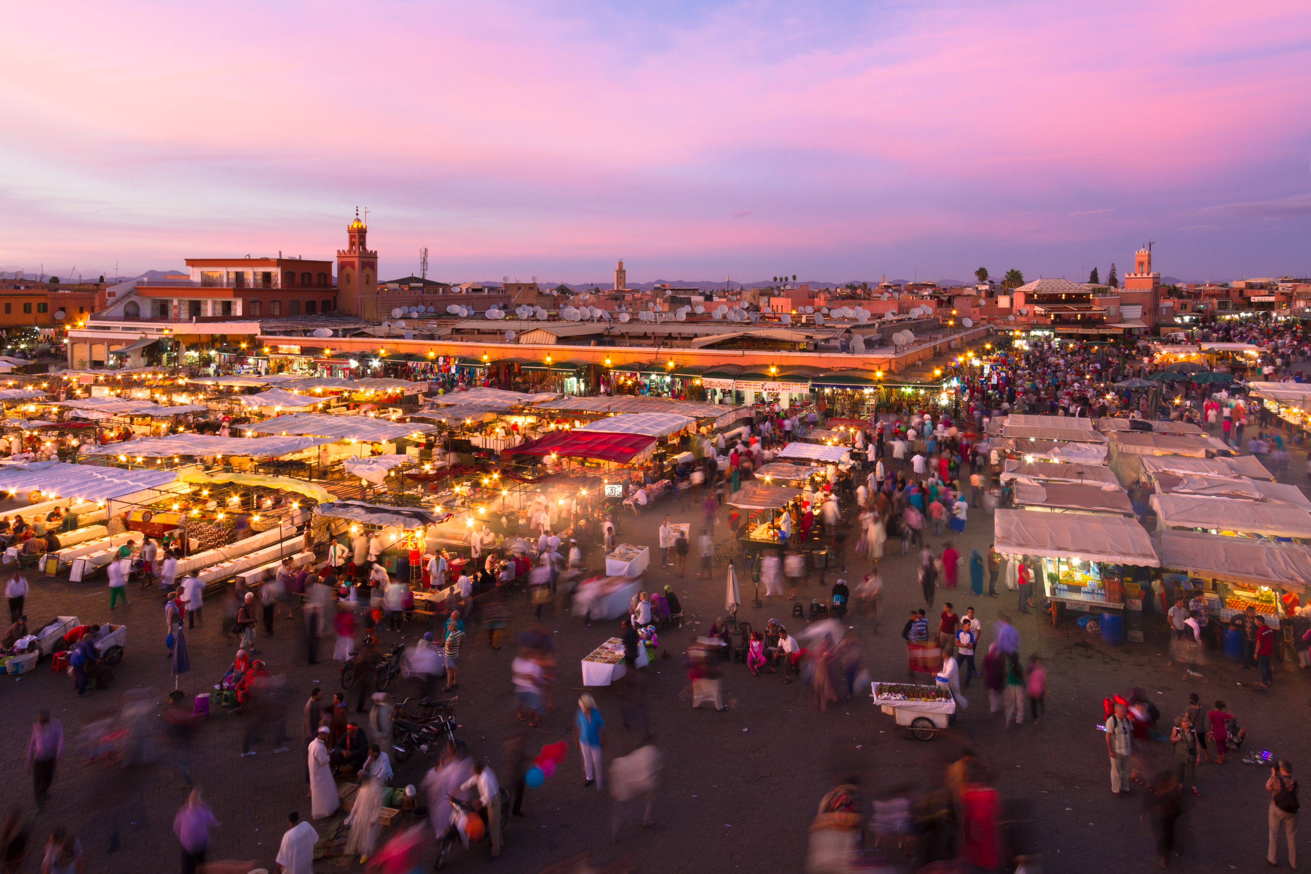 Den historiske Jamaa el Fna plads i Marrakech, Marokko ved solnedgang med livlige madboder, handlende og lokale besøgende. UNESCO verdensarv.