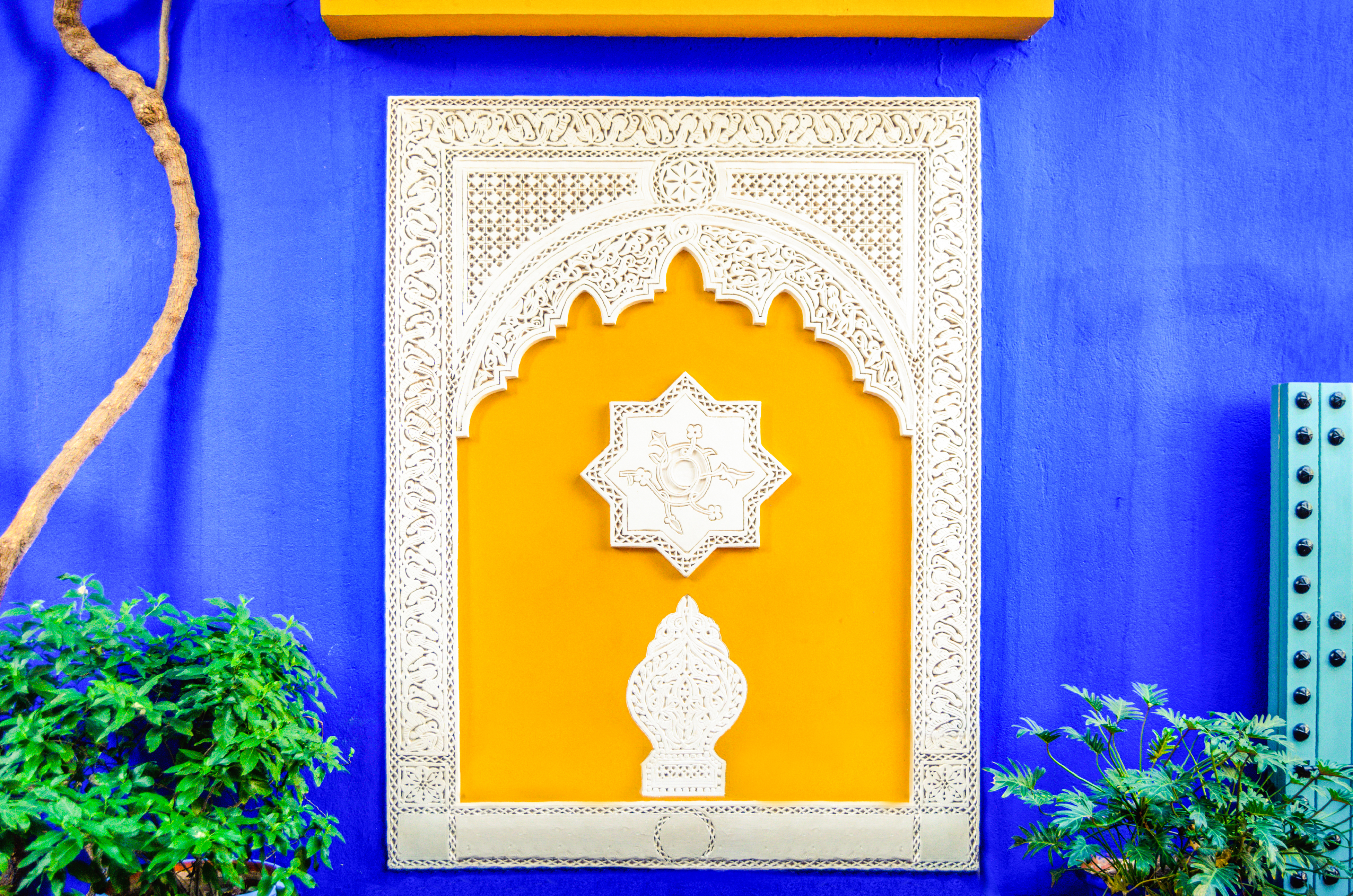 Farverigt gult vindue i Jardin Majorelle, Marrakech - Yves Saint Laurents tidligere hjem med karakteristisk blå facade og islamisk arkitektur