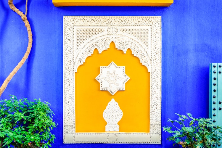 Farverigt gult vindue i Jardin Majorelle, Marrakech - Yves Saint Laurents tidligere hjem med karakteristisk blå facade og islamisk arkitektur