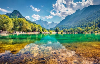 Betagende udsigt over den turkisblå Jasna-sø med spejlbillede af de majestætiske Juliske Alper i Triglav Nationalpark, Slovenien