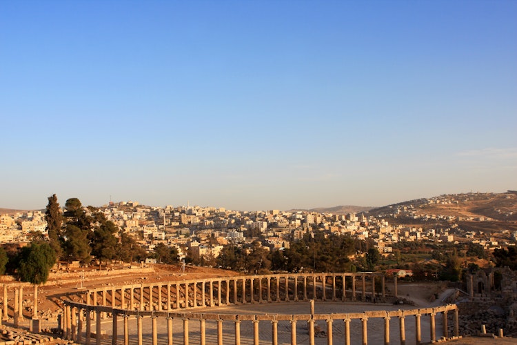 Historiske romerske søjler i det antikke Gerasa med udsigt over moderne Jerash i Jordan
