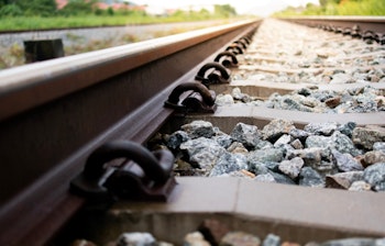 Nærbillede af jernbanespor der strækker sig mod horisonten, symboliserer rejseeventyr og nye destinationer med Smil Rejser