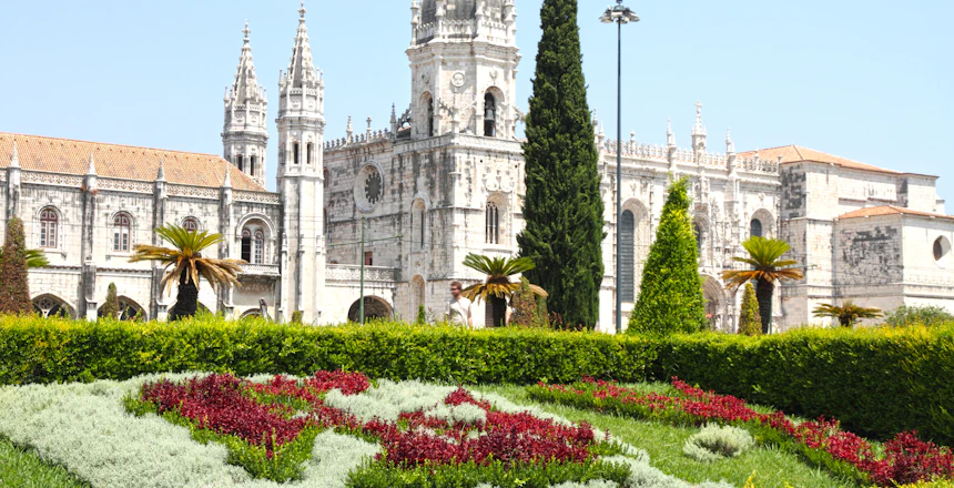 Historiske Jeronimos Kloster med gotisk arkitektur og farverig have i Belem, Lissabon, Portugal