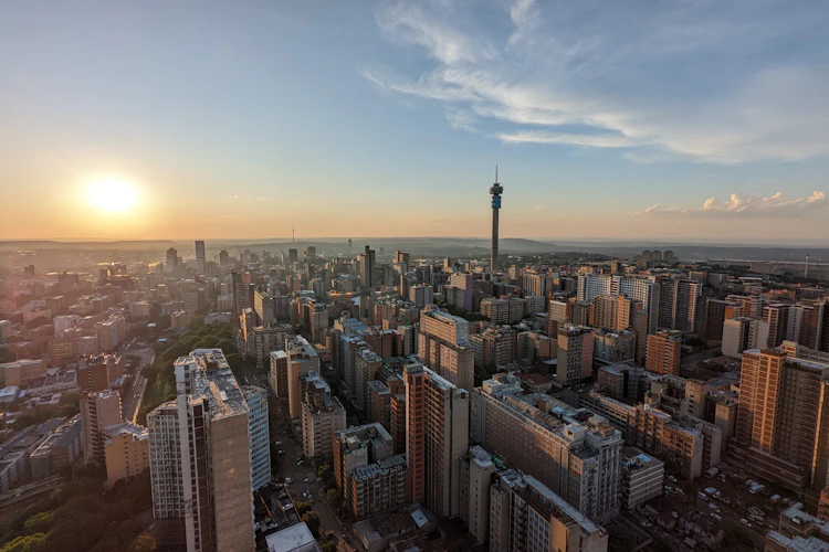 Luftfoto af Johannesburgs byhorisont ved solnedgang med Hillbrow Tower og moderne bygninger
