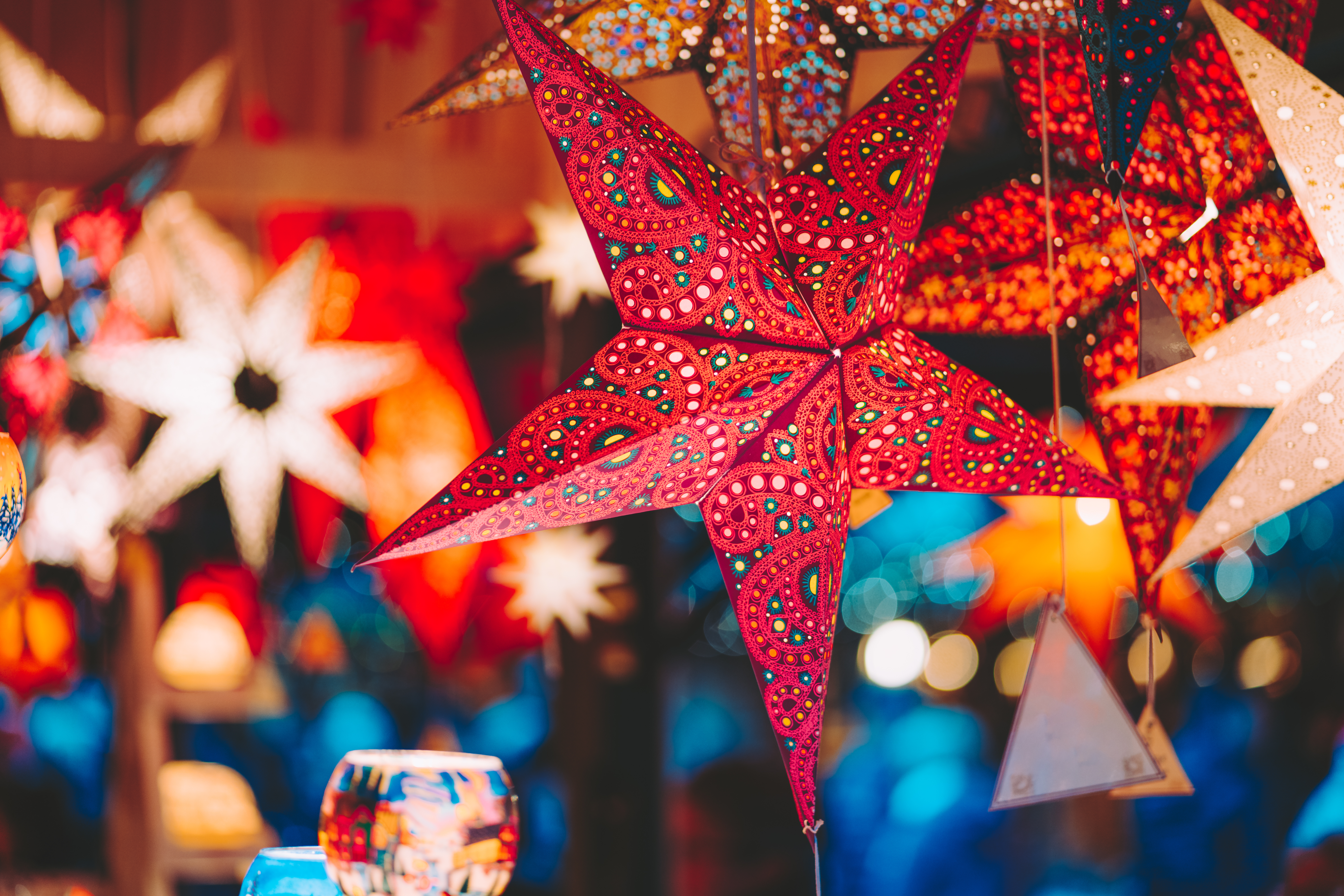 Farverige julestjerner og lygter på europæisk julemarked med varm festbelysning