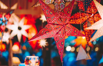 Farverige julestjerner og lygter på europæisk julemarked med varm festbelysning