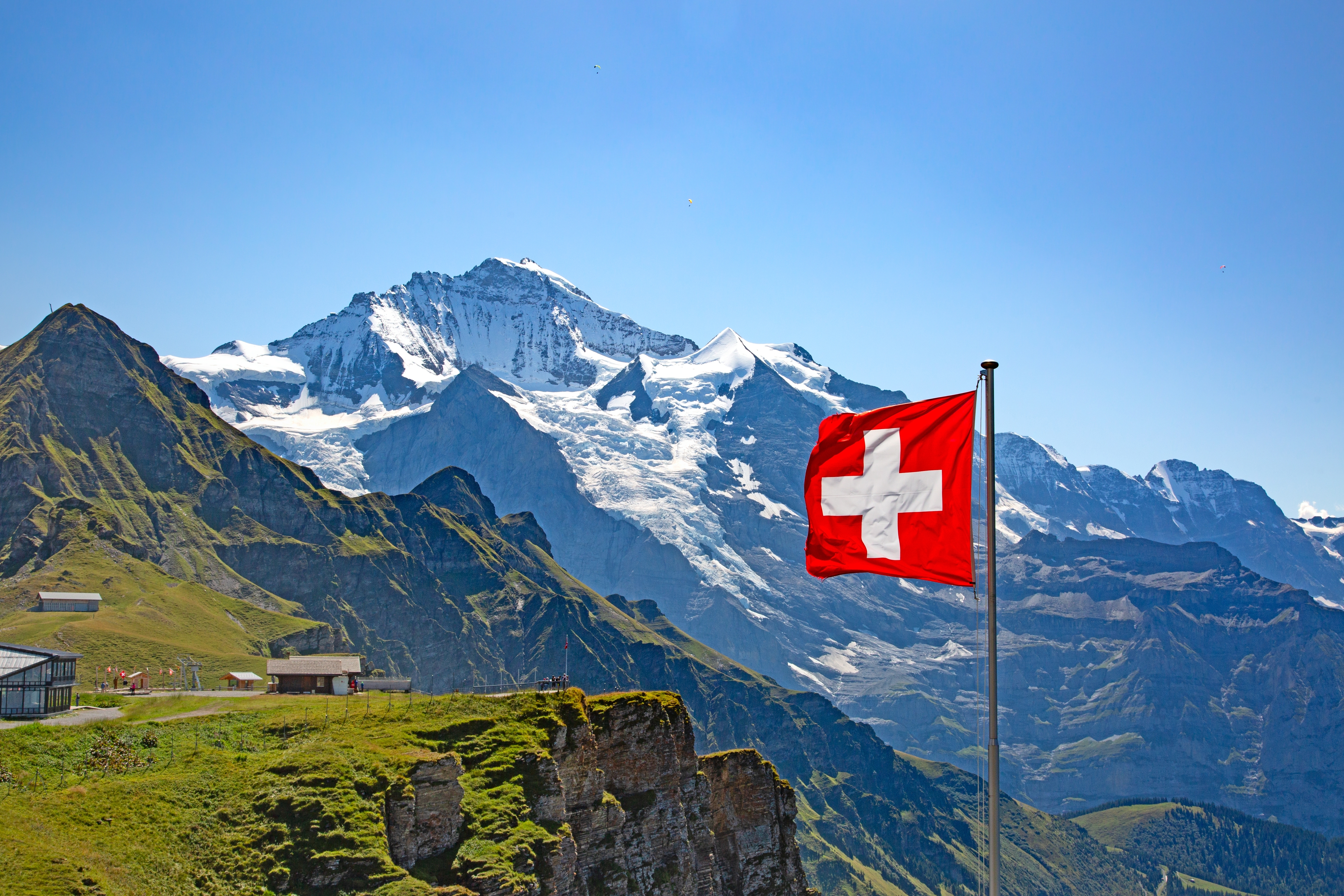 Betagende sommerlandskab i Jungfrau-regionen med snedækkede alpetinder mod en klar blå himmel i det schweiziske Bernese Oberland