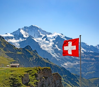 Betagende sommerlandskab i Jungfrau-regionen med snedækkede alpetinder mod en klar blå himmel i det schweiziske Bernese Oberland