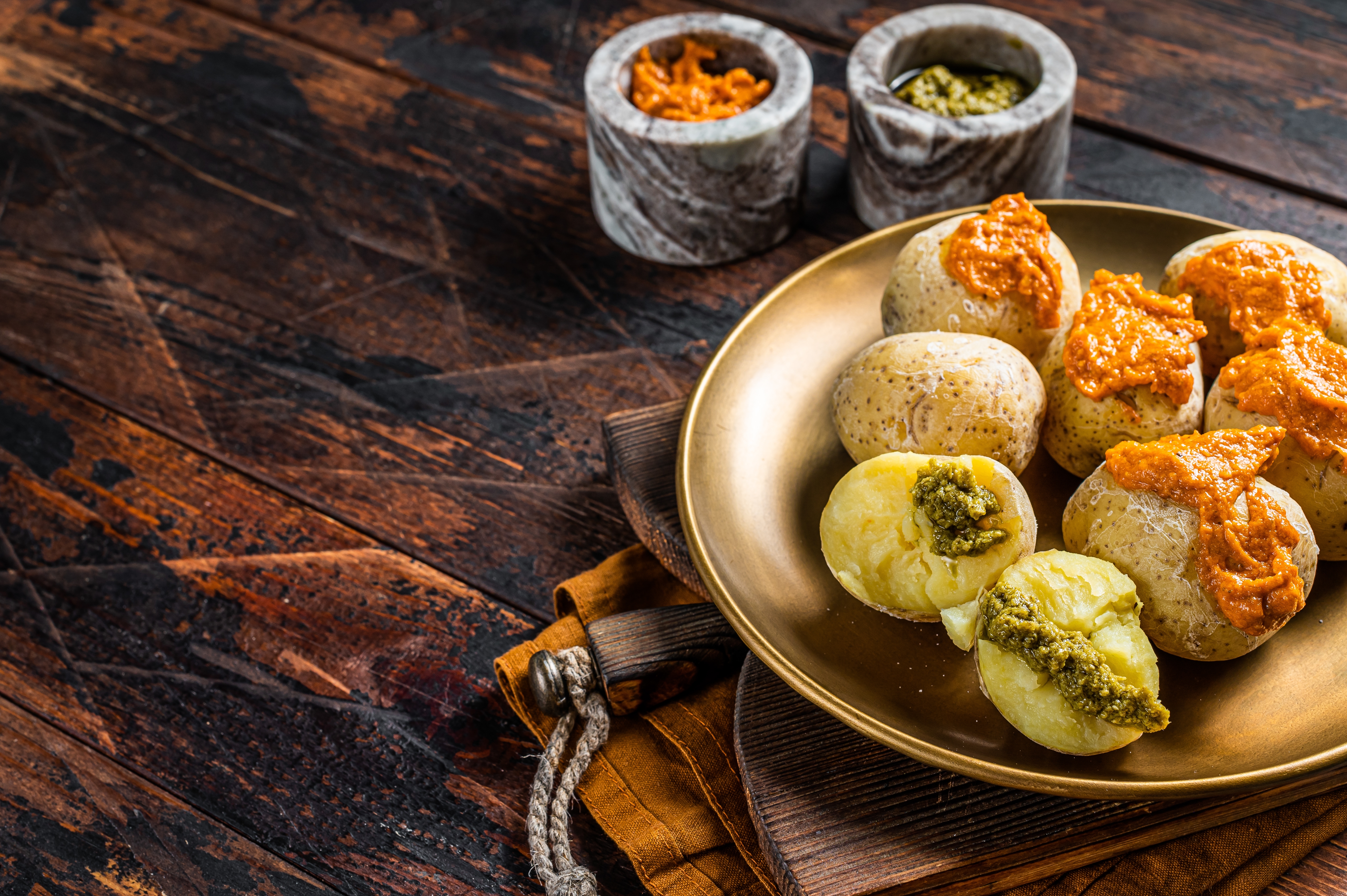 Traditionel kanarisk specialitet Papas Arrugadas (rynkede kartofler) med krydret rød Mojo picon sauce serveret på træbaggrund