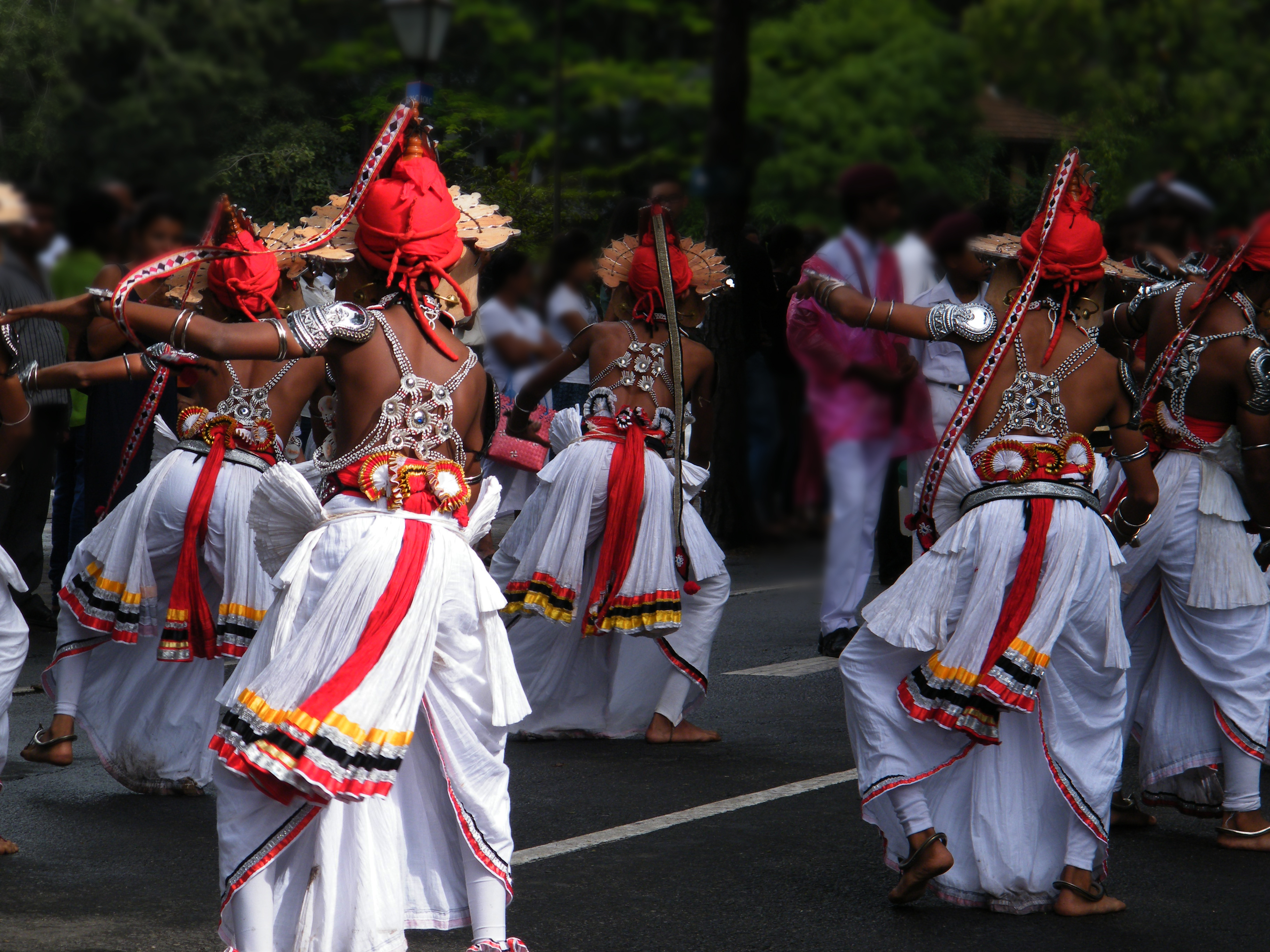Farverige traditionelle Ves-dansere i ceremonielle dragter under en kulturel procession i Kandy, Sri Lanka. En levende fremvisning af buddhistisk kulturarv fra højlandet