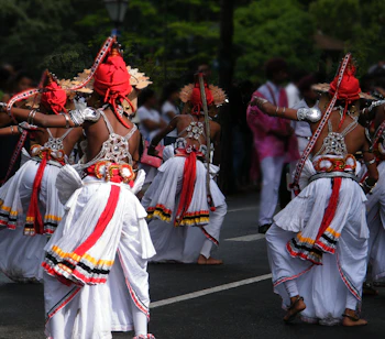 Farverige traditionelle Ves-dansere i ceremonielle dragter under en kulturel procession i Kandy, Sri Lanka. En levende fremvisning af buddhistisk kulturarv fra højlandet