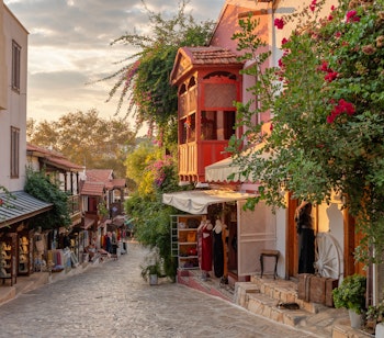 Hyggelig gade med farverige butikker i den gamle bydel i Kas ved solnedgang - en charmerende middelhavsby på Tyrkiets sydkyst