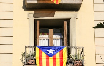 Katalanske uafhængighedsflag (Estelada) hænger fra lejlighedsbalkoner i Barcelona, symboliserer lokal kultur og identitet i Catalonien