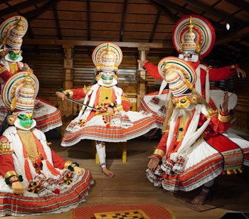 Farverige Kathakali-dansere med traditionel makeup under en kulturel forestilling i Kerala, Sydindien