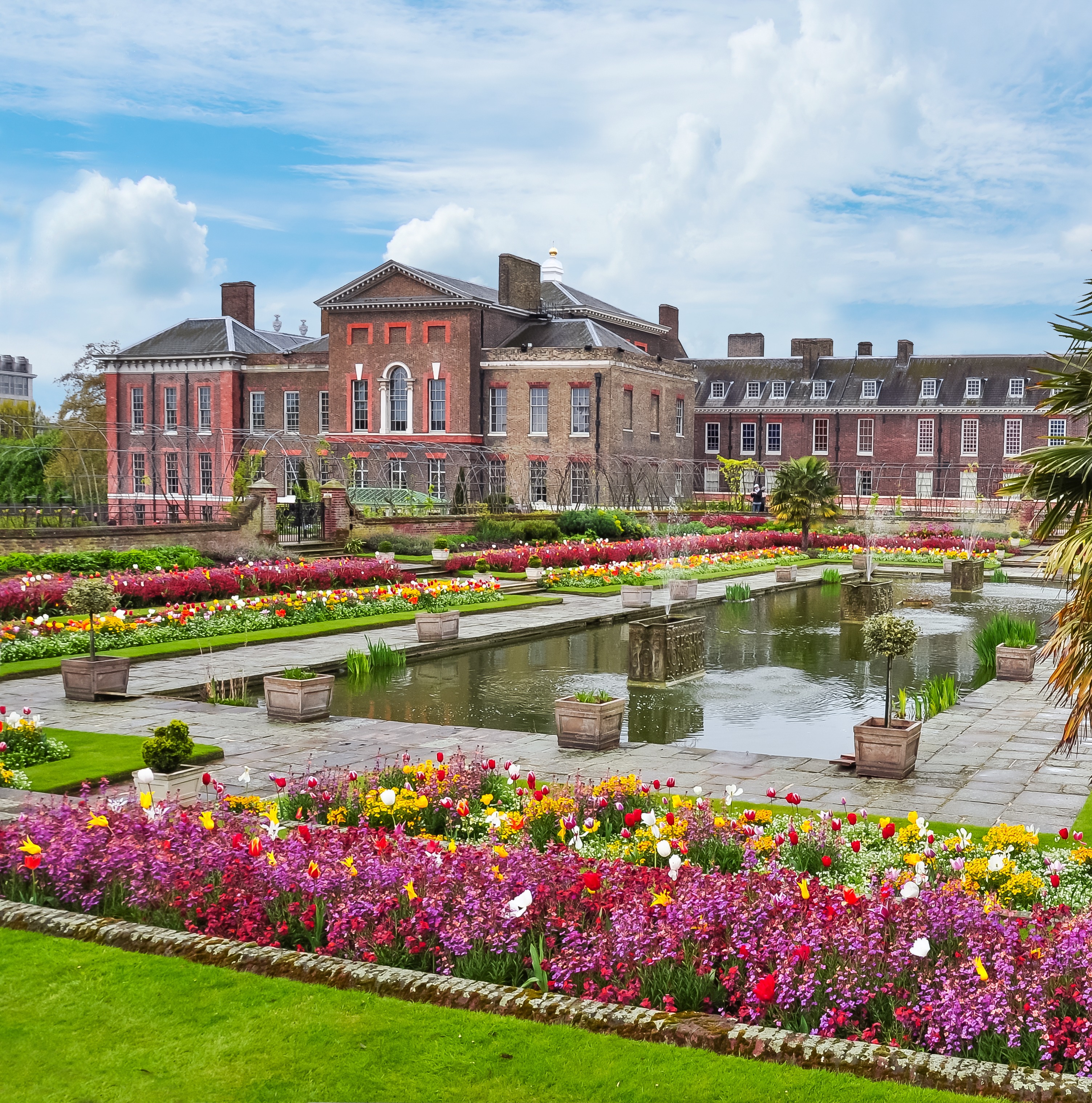 Kensington Palace i London med smukke formelle haver fyldt med farverige tulipaner og en spejlsø om foråret