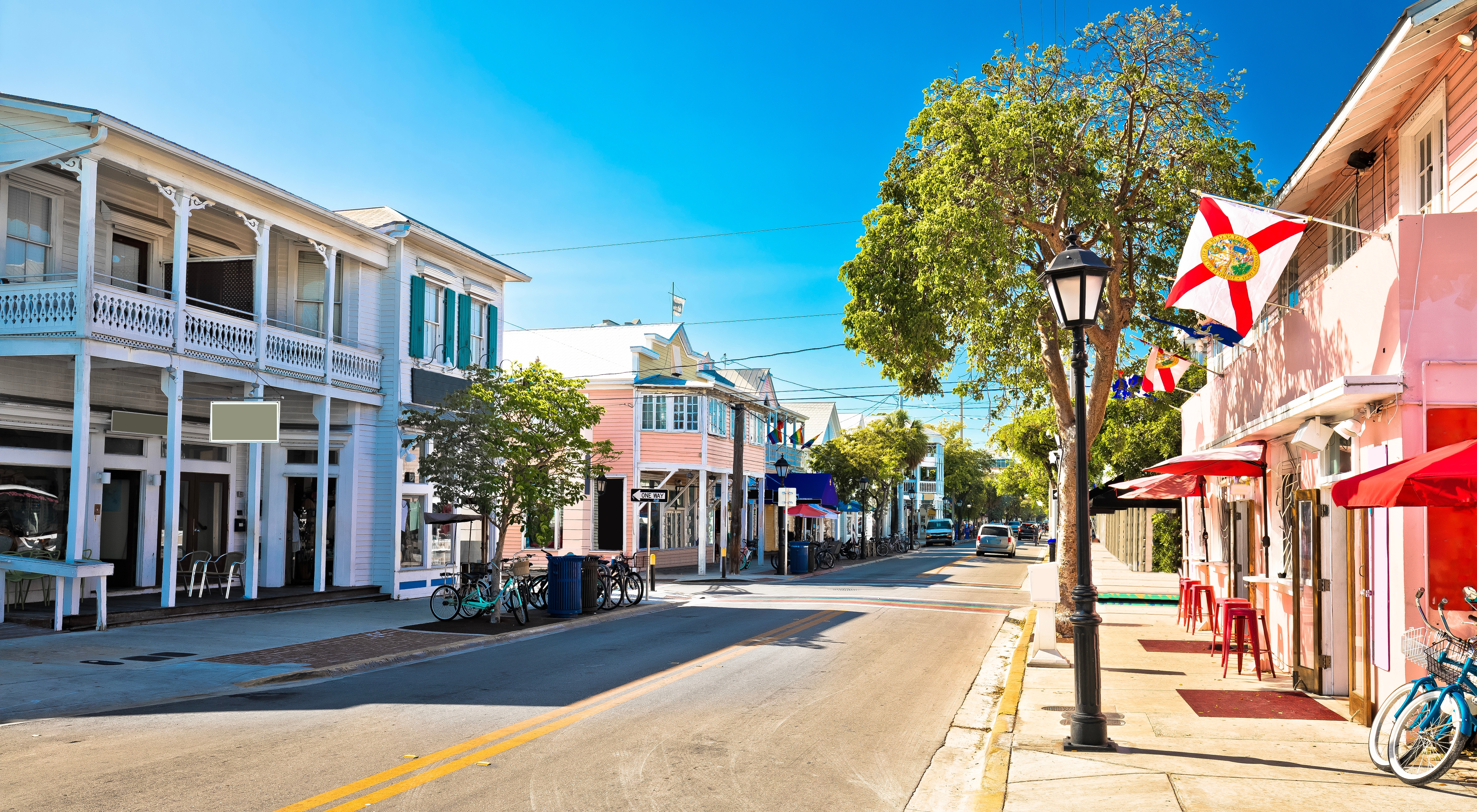 Panoramisk udsigt over den berømte Duval Street i Key West, Florida Keys, med farverige bygninger og tropisk vegetation - et livligt centrum for USA's sydligste feriedestination