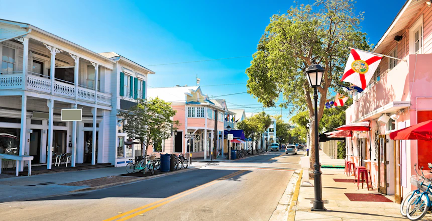 Panoramisk udsigt over den berømte Duval Street i Key West, Florida Keys, med farverige bygninger og tropisk vegetation - et livligt centrum for USA's sydligste feriedestination