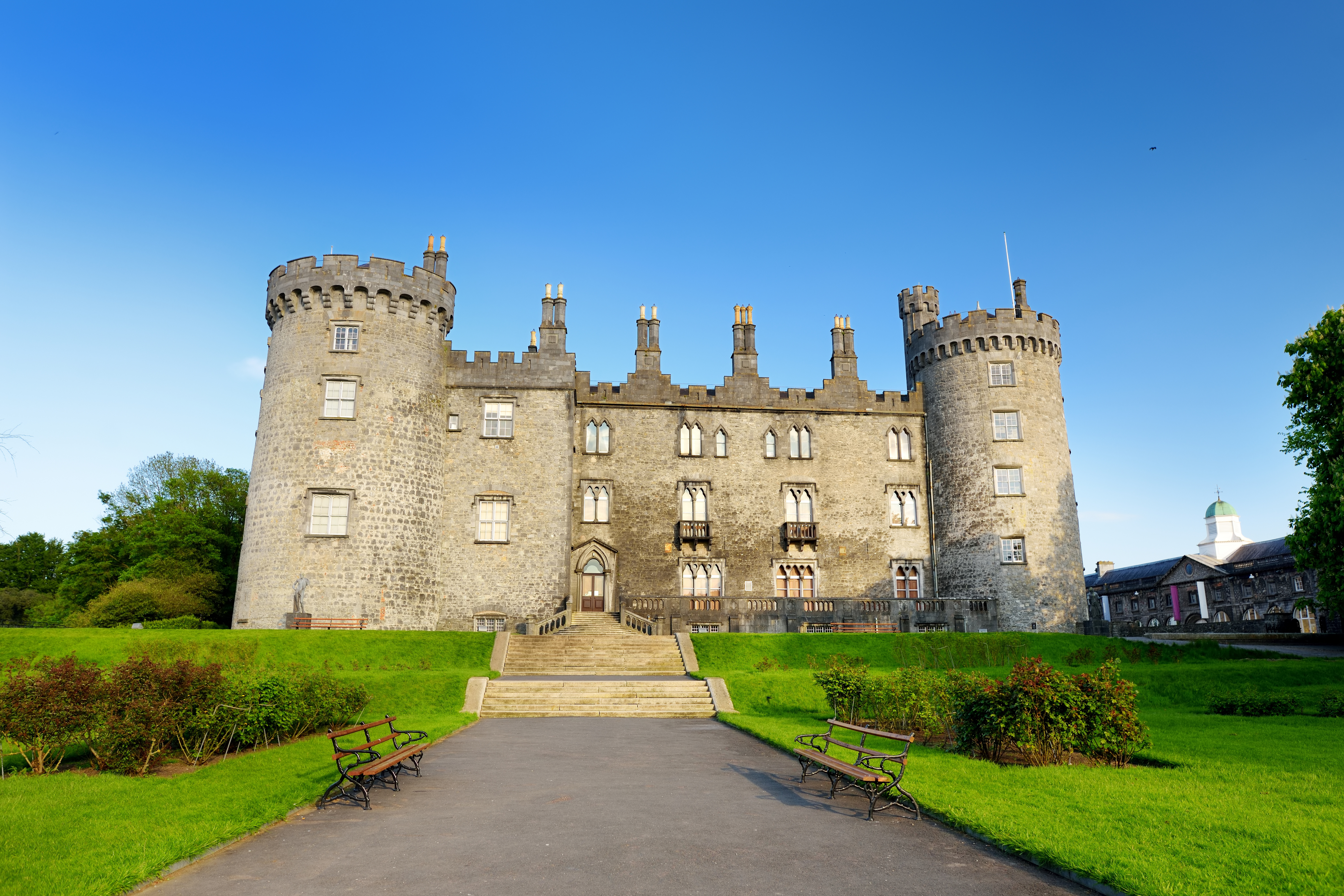 Kilkenny Castle med to karakteristiske tårne og velplejet grønt parkanlæg i Kilkenny, Irland