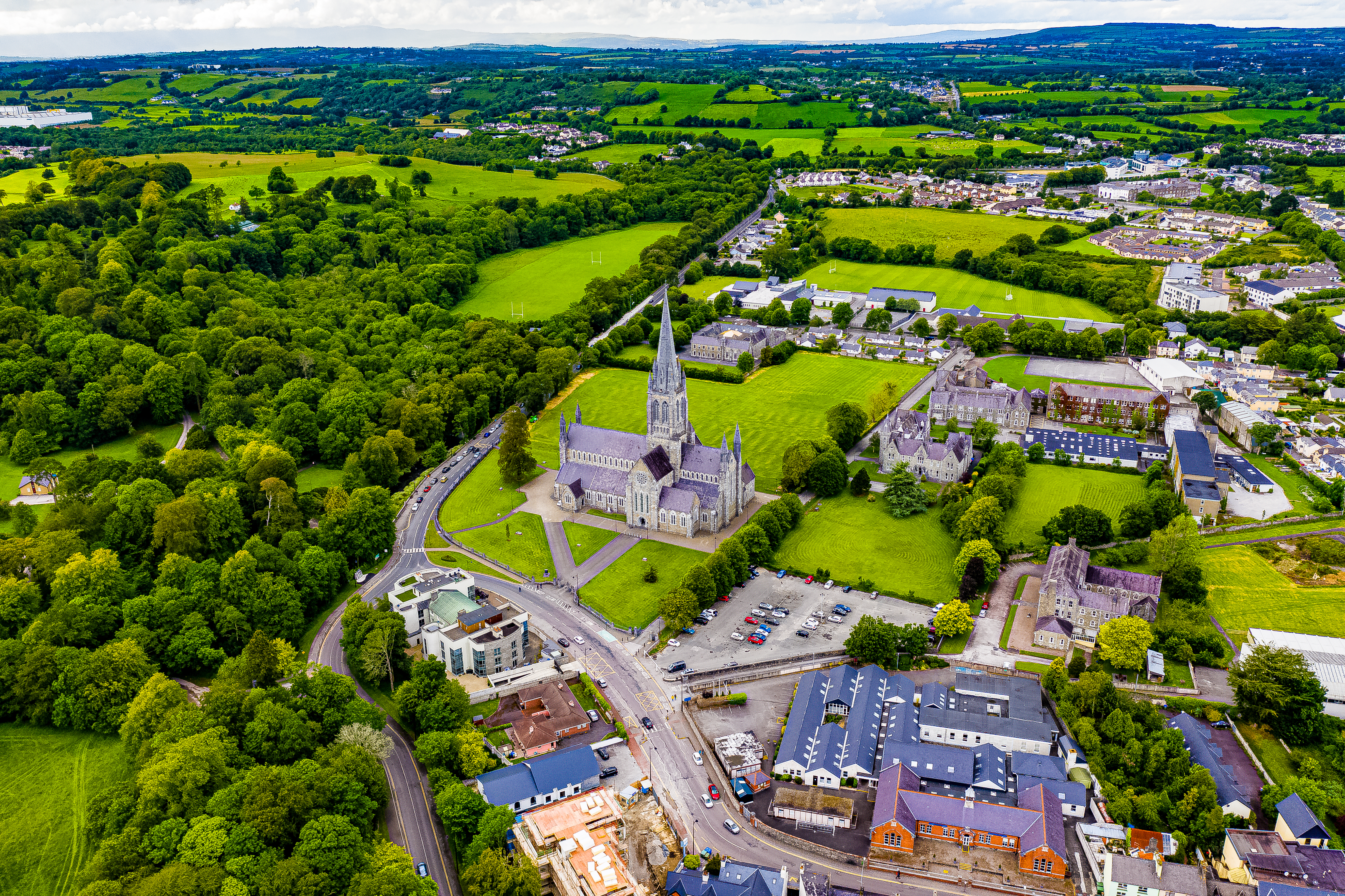 Luftfoto af den historiske Killarney domkirke og by omgivet af grønne marker i County Kerry Irland