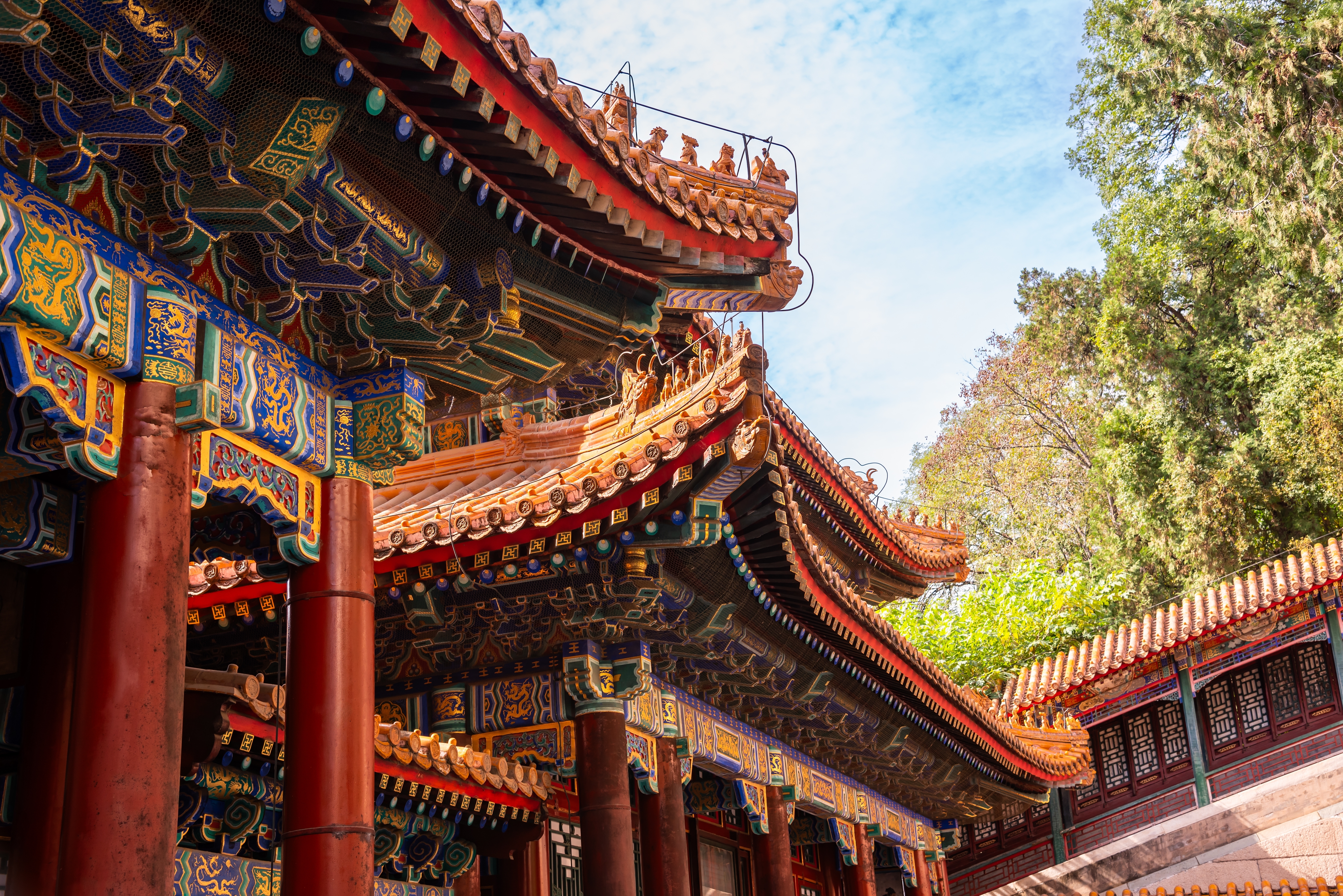 Traditionel kinesisk arkitektur ved Sommerpaladset i Beijing med røde søjler og udsmykkede tage