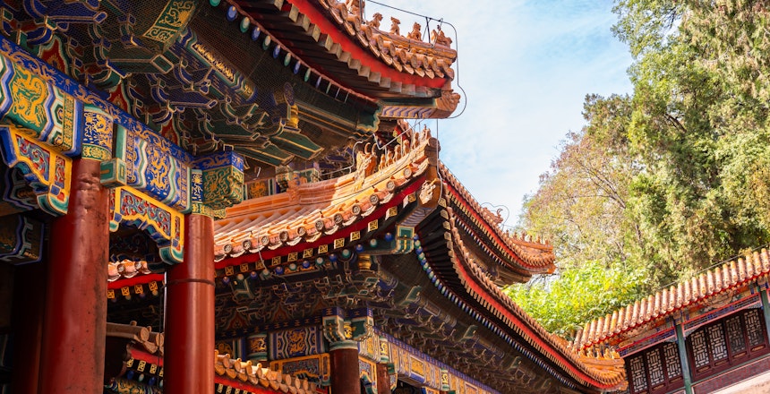 Traditionel kinesisk arkitektur ved Sommerpaladset i Beijing med røde søjler og udsmykkede tage