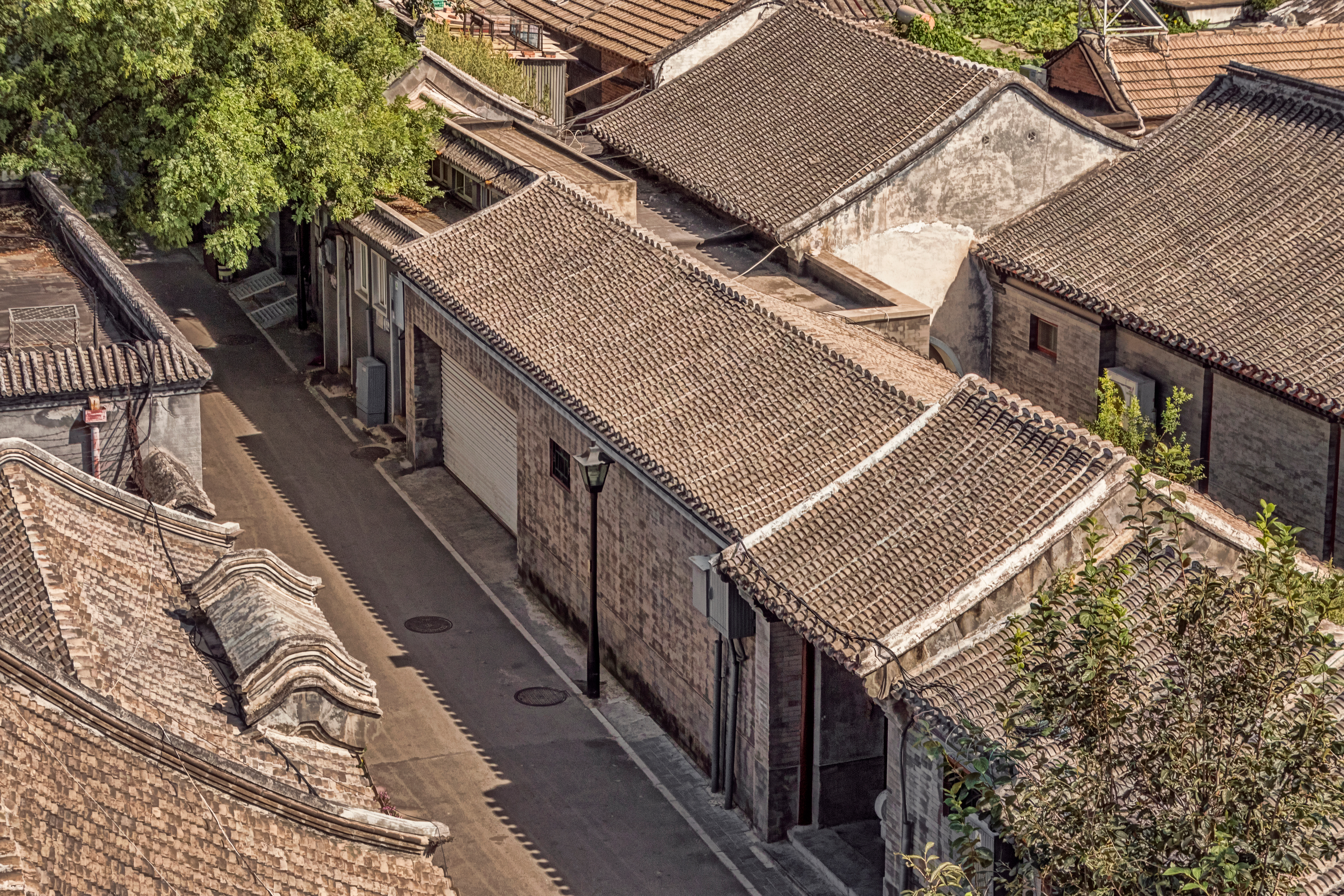 Luftfoto af traditionelt kinesisk hutong-kvarter med historiske stenbygninger og tegltage i Beijing