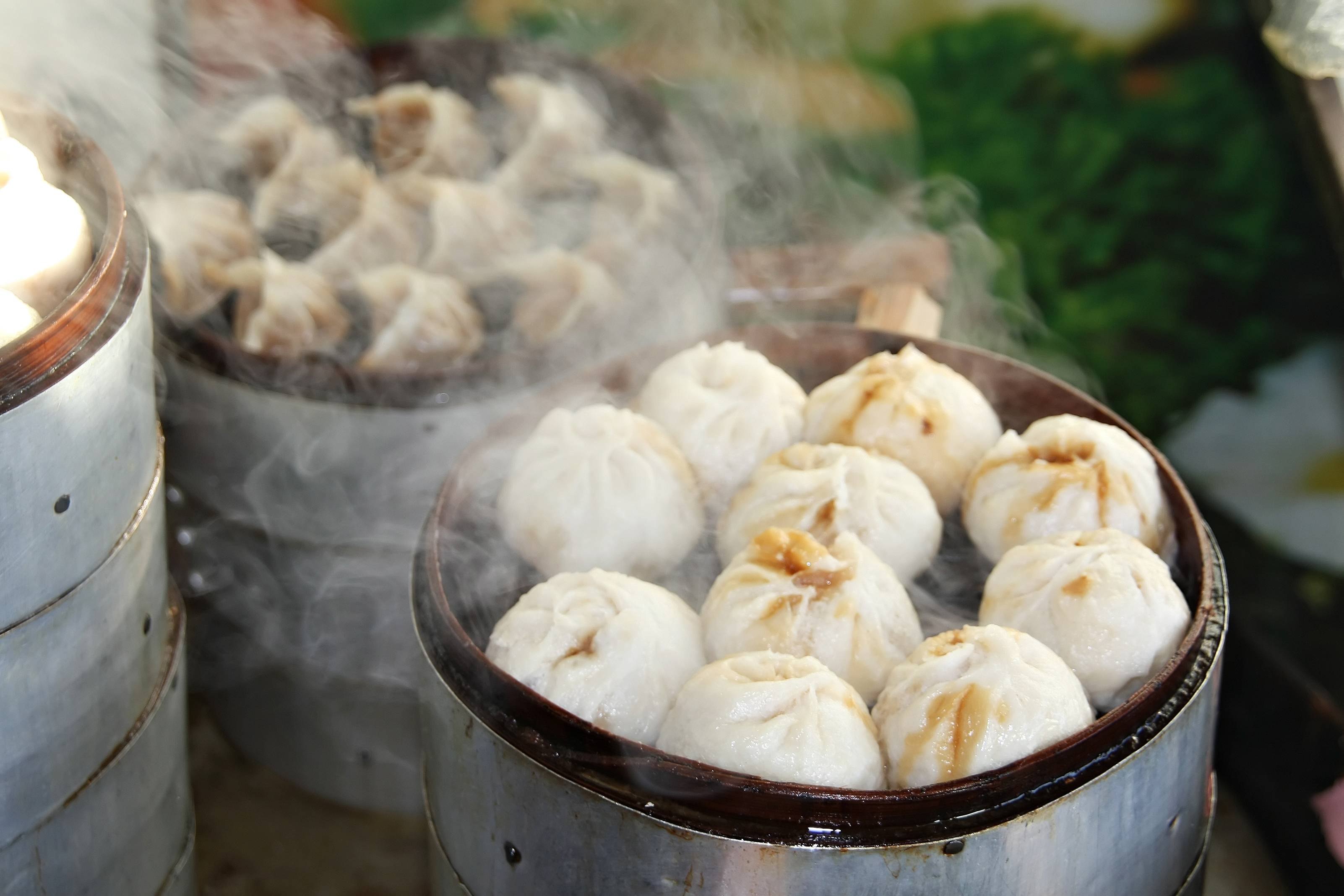 Dampende kinesiske dim sum dumplings serveret i traditionelle bambuskurve