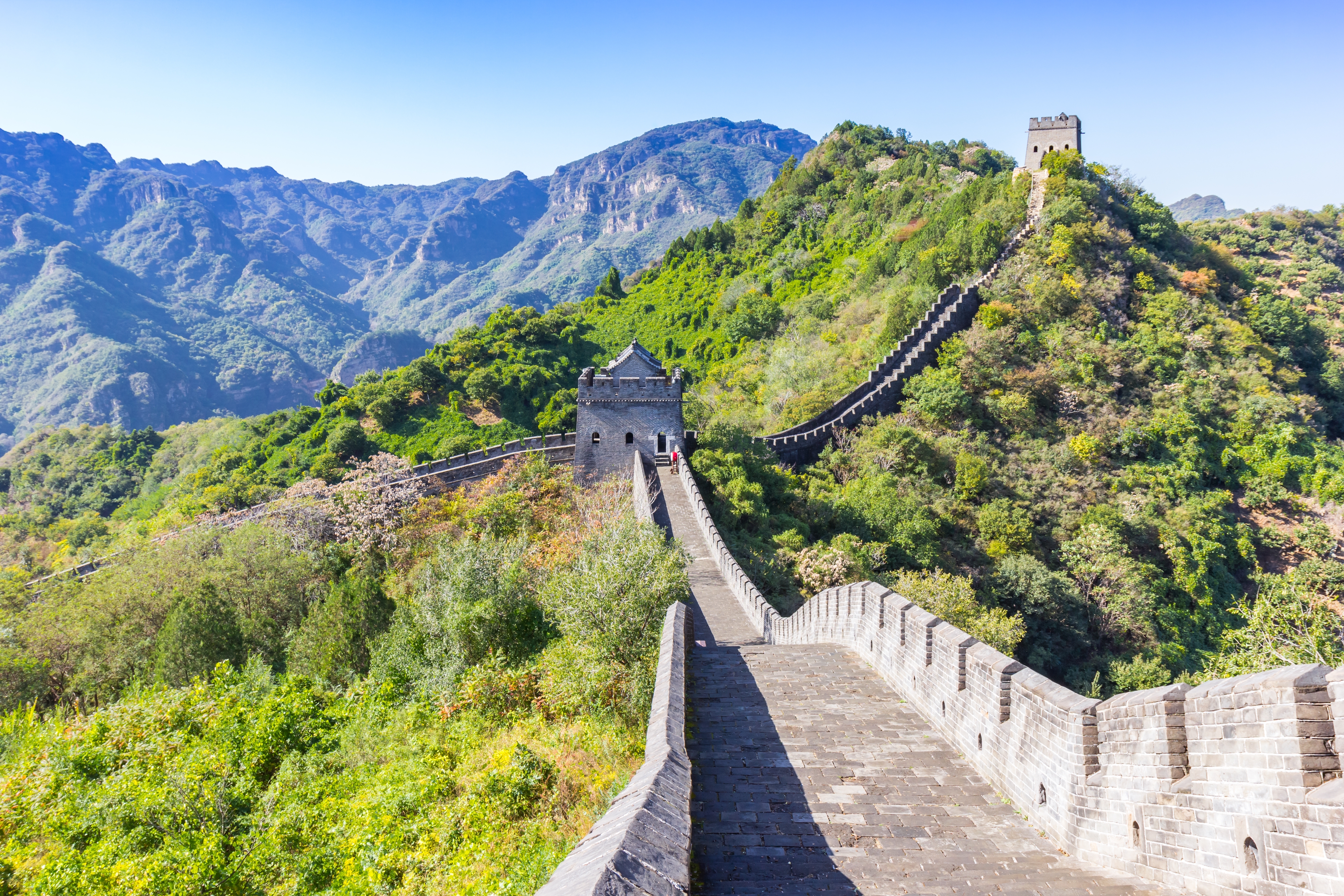 Den Kinesiske Mur slynger sig gennem grønne bjerge med vagttårne og smukt landskab