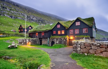 Traditionelle græstag huse i Kirkjubour landsby på Færøerne ved solnedgang