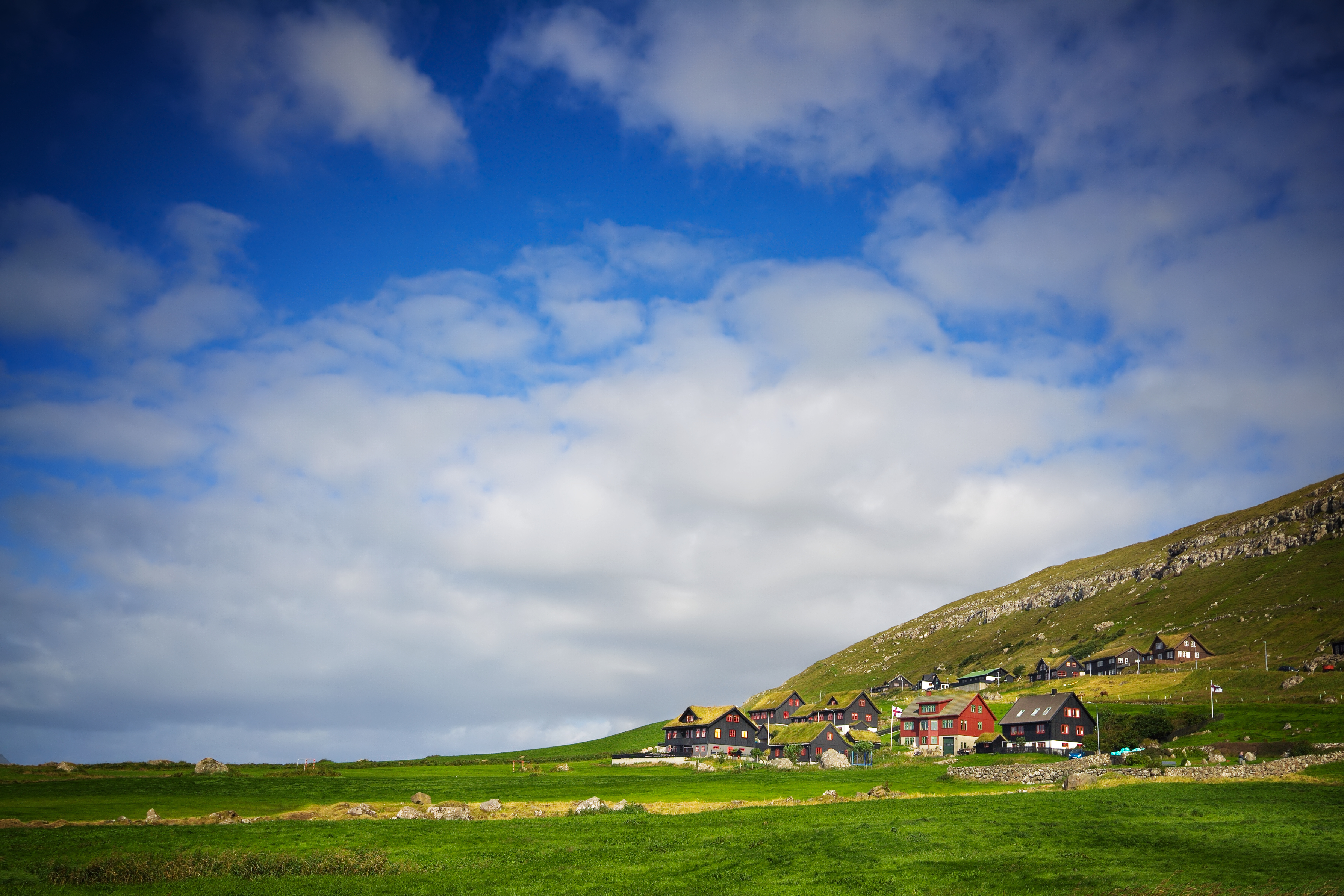 Den historiske landsby Kirkjubøur på Færøerne med traditionelle huse omgivet af grønne bakker og atlanterhavsudsigt