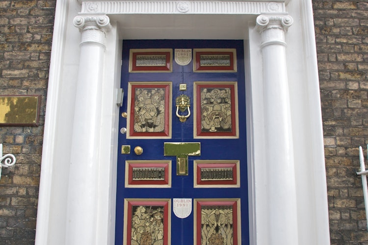 Klassisk blå dør med hvid dørkarm og buet vindue i typisk georgisk stil fra Dublin, Irland