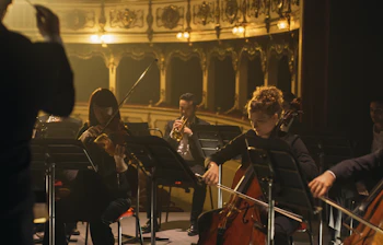 Symfoniorkester der fremfører klassisk musik på scenen i et historisk teater under en kulturrejse