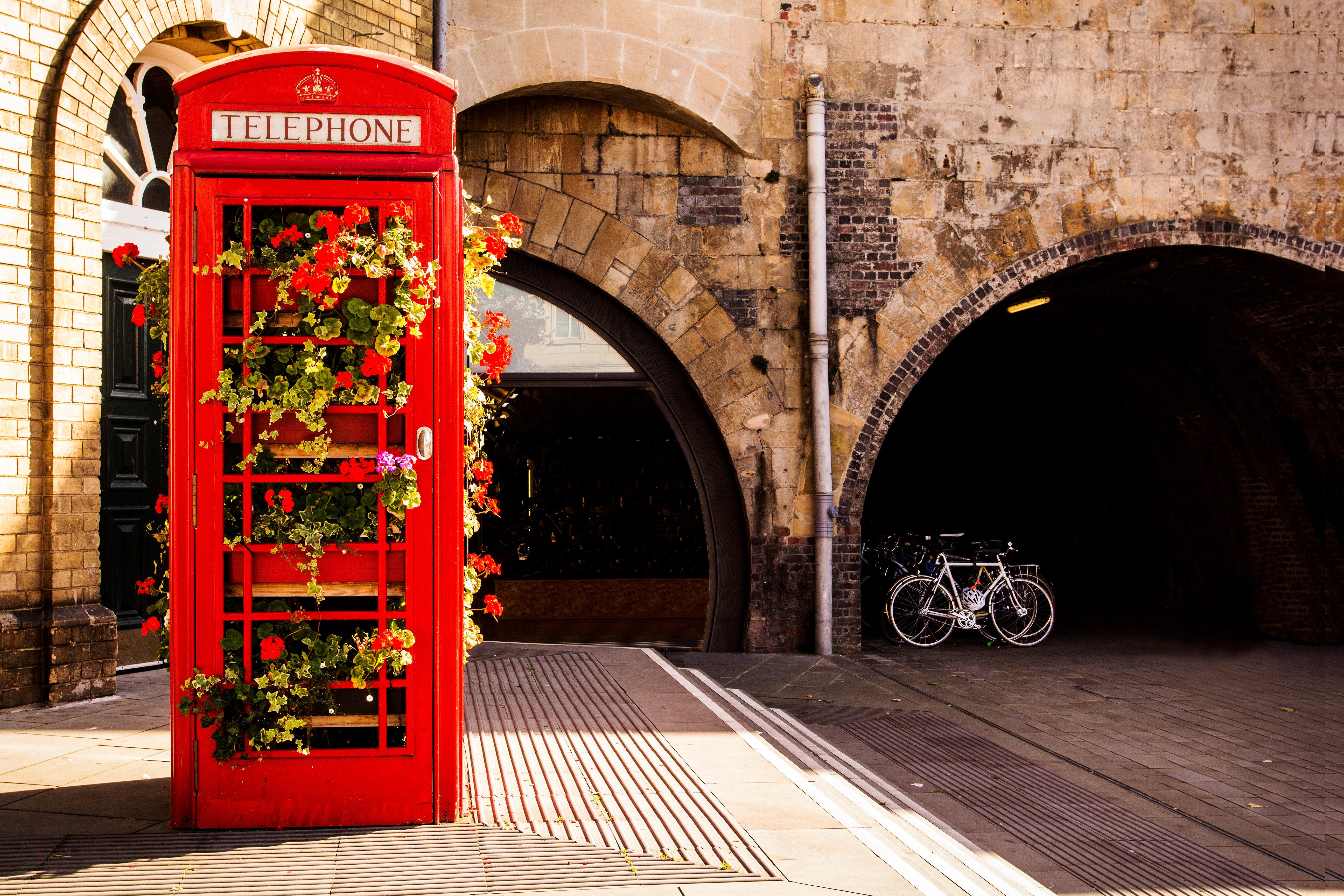 Traditionel rød engelsk telefonboks dekoreret med farverige blomster i den historiske by Bath, England
