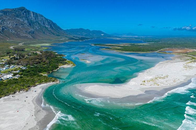 Betagende luftfoto af Klein River-lagunen der møder havet ved Hermanus i Western Cape-provinsen, Sydafrika