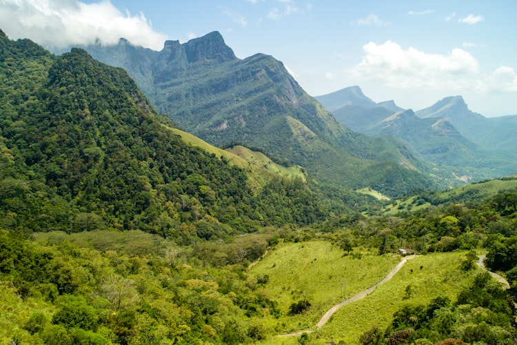 Panoramaudsigt over de frodige grønne Knuckles-bjerge og dale i Meemure, Sri Lanka med tropisk skov og blå himmel