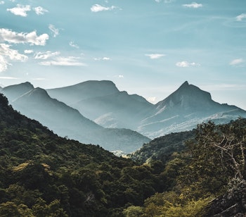 Betagende udsigt over Knuckles bjergkæden i Sri Lanka med tågedækkede bjergtinder og frodige grønne skove