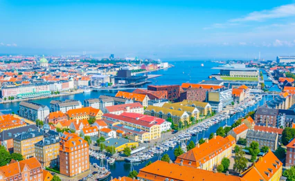 Luftfoto af København havn med orange tage og både