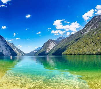 Idyllisk udsigt over Königssee med St. Bartholomæus-kapellet omgivet af majestætiske alper i Bayerns naturskønne Berchtesgaden nationalpark
