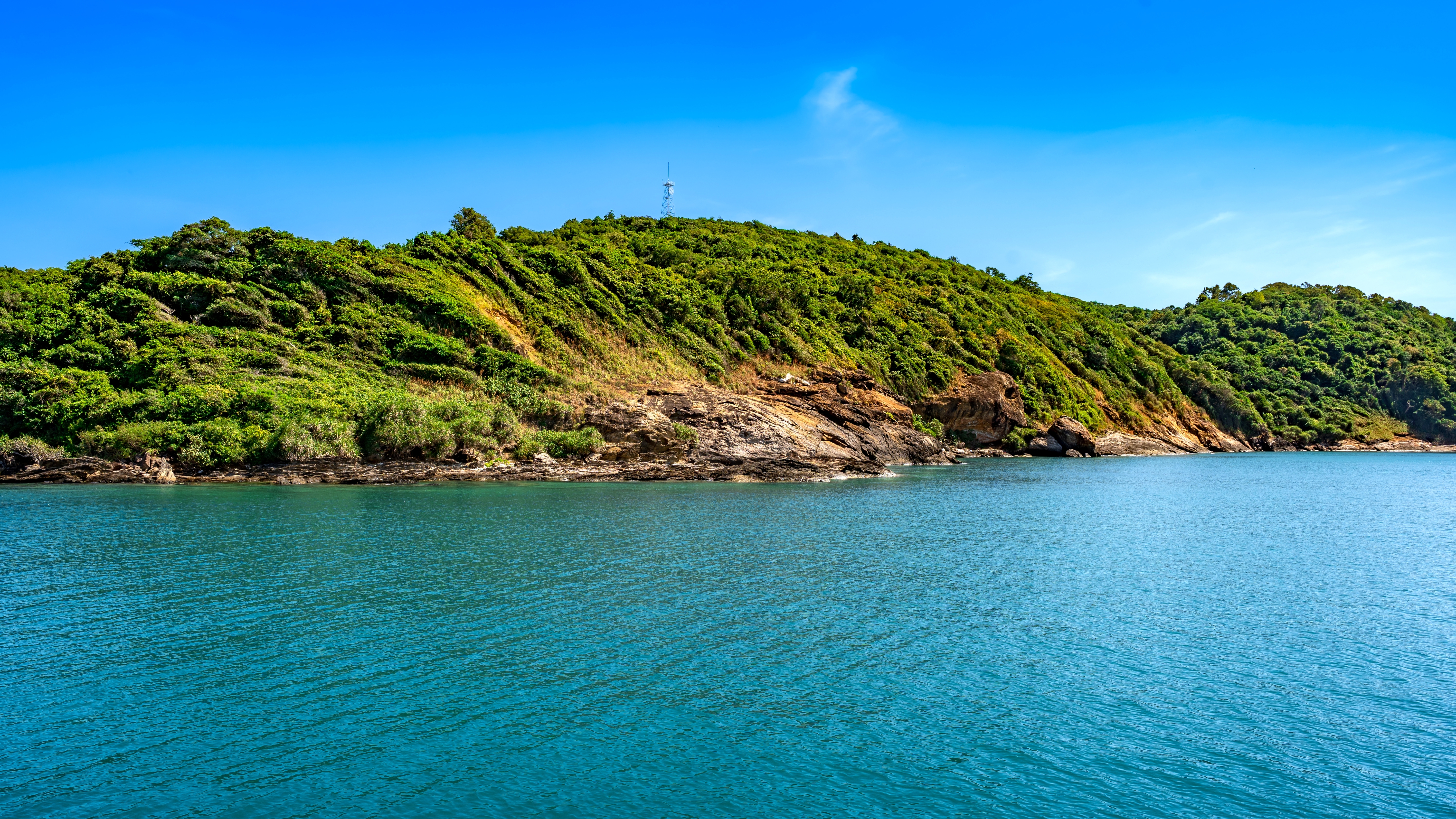 Panoramaudsigt over den frodige tropiske kystlinje på Koh Samed med turkisblåt vand og klar blå himmel, Rayong, Thailand