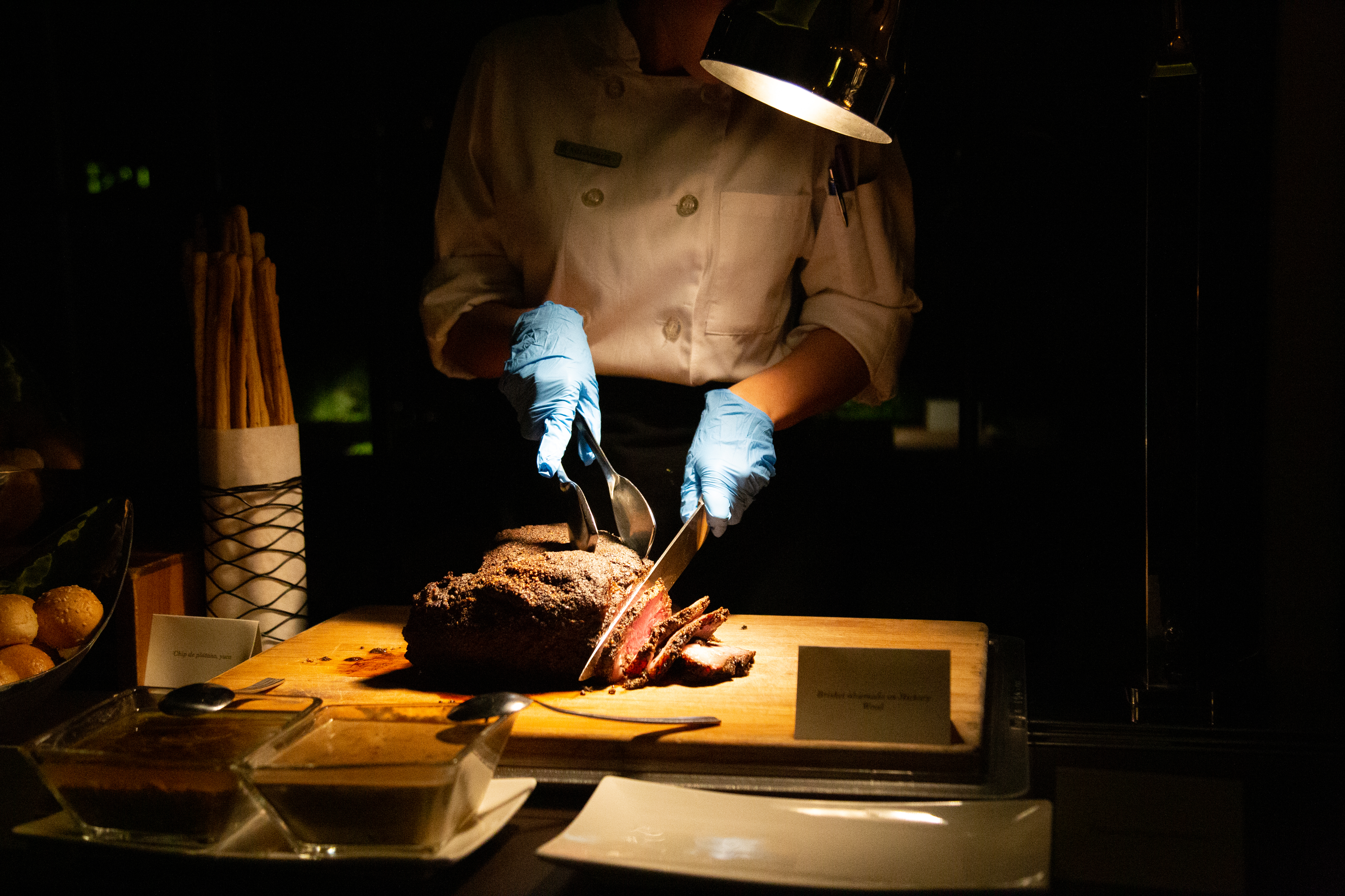 Professionel kok skærer krydret brisket med præcision i køkkenet