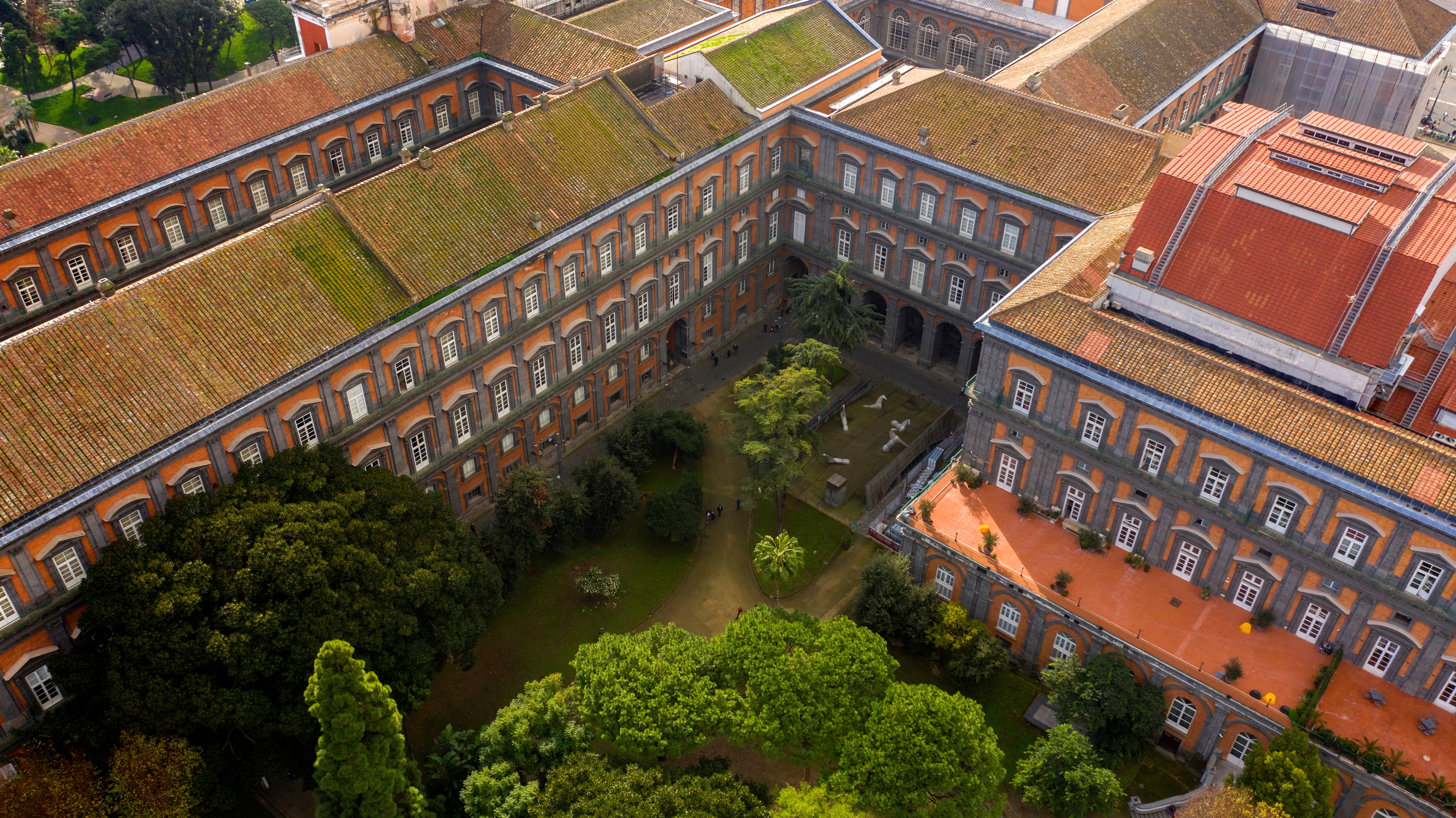 Luftfoto af den kongelige paladspark i Napoli, Italien, med smukke grønne haver og historisk neoklassisk arkitektur