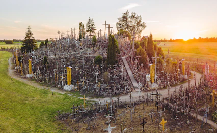 Korsenes Bakke pilgrimsmål ved solnedgang i Siauliai Litauen med tusindvis af træ kors