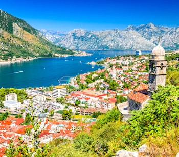 Panoramaudsigt over Kotor-bugten i Montenegro med den historiske middelalderby, venetianske fæstningsmure og dramatiske bjerge ved Adriaterhavets kyst