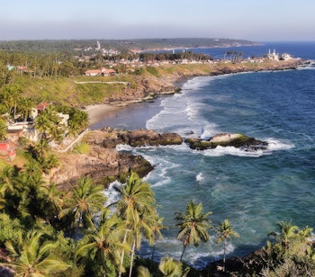 Betagende udsigt fra fyrtårnet i Kovalam over de tropiske sandstrande og det azurblå Arabiske Hav langs Malabarkysten i Kerala, Sydindien