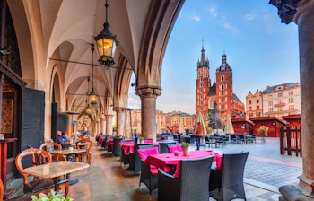 Restaurant terrasse med udsigt til Krakows hovedtorv og Skt. Maria Kirkens tårne i Polen